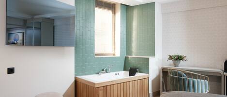 Un baño moderno con tocador de madera, un espejo grande y una ventana con persianas.