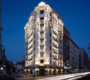 A multi-story hotel with a corner entrance, large windows, and a prominent entrance with a canopy. - Perla Pura Hotel (Izmir)