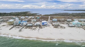 Ett område vid kusten med fastigheter som ligger direkt vid stranden, varav några har upphöjda byggnader, och med utsikt över havet.