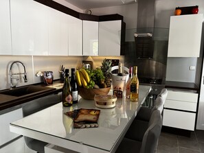 Enjoy cooking and dining in this well-equipped kitchen with a central island, white cabinetry, and dishwasher.