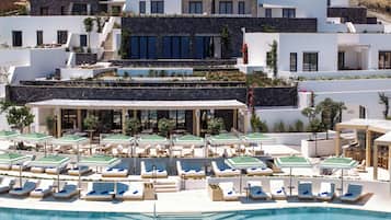 A modern resort with a pool area, sun loungers, and a restaurant with outdoor seating.