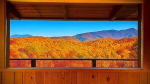 A room with a large window overlooking a forested mountain range. - Stunning Mtn View, True Log Cabin, Romance Getaway, Rare Find (Gatlinburg)