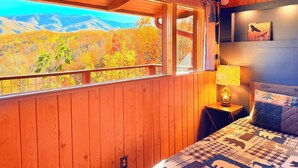 A wooden cabin room with a large window overlooking a mountainous landscape. - Stunning Mtn View, True Log Cabin, Romance Getaway, Rare Find (Gatlinburg)