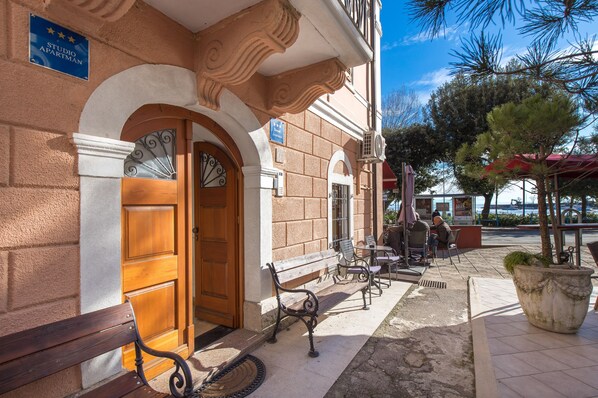 Traditional hotel entrance with a welcoming wooden door and decorative metal gate.
