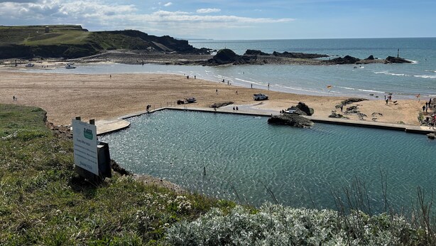 A coastal view with a swimming pool, beach, and rocky cliffs. - 3 bedroom accommodation in Bude (Bude)