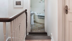 A staircase leading to a bathroom with a sink and a bathtub. - 3 bedroom accommodation in Bude (Bude)