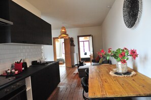 Apartamento família, vista para o pátio | Cozinha privada | Geladeira grande, micro-ondas, fogão, cooktop