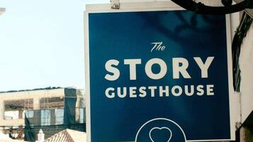 En skylt för ”The Story Guesthouse” med en maritim symbol.