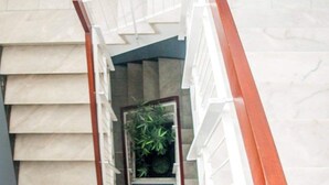 A staircase with a wooden handrail leading to a landing. - The Story Guest House  (Faro)