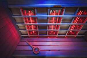 Una sauna con varias bancas y suelo de madera.