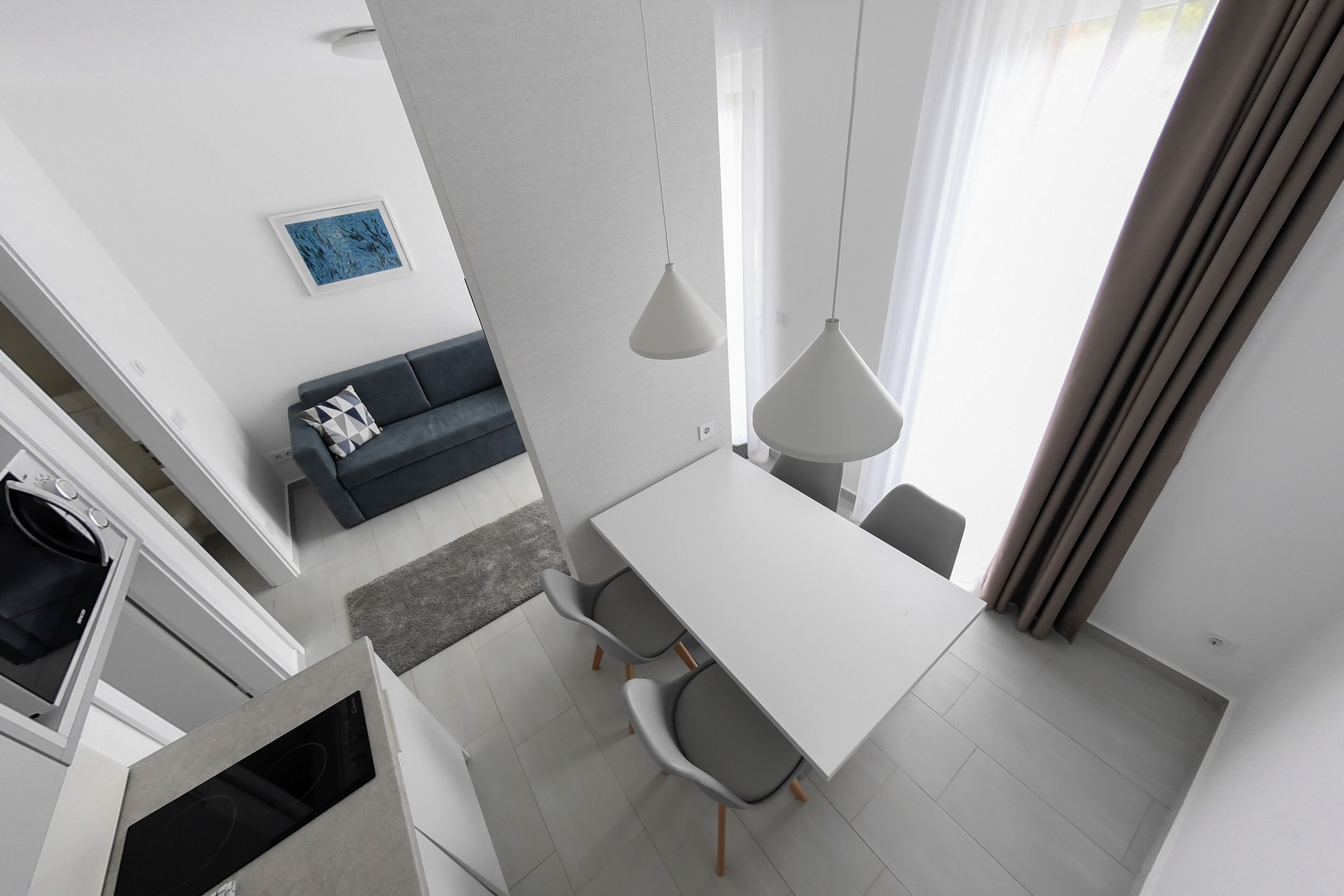 A modern kitchen with white cabinetry and a built-in oven.