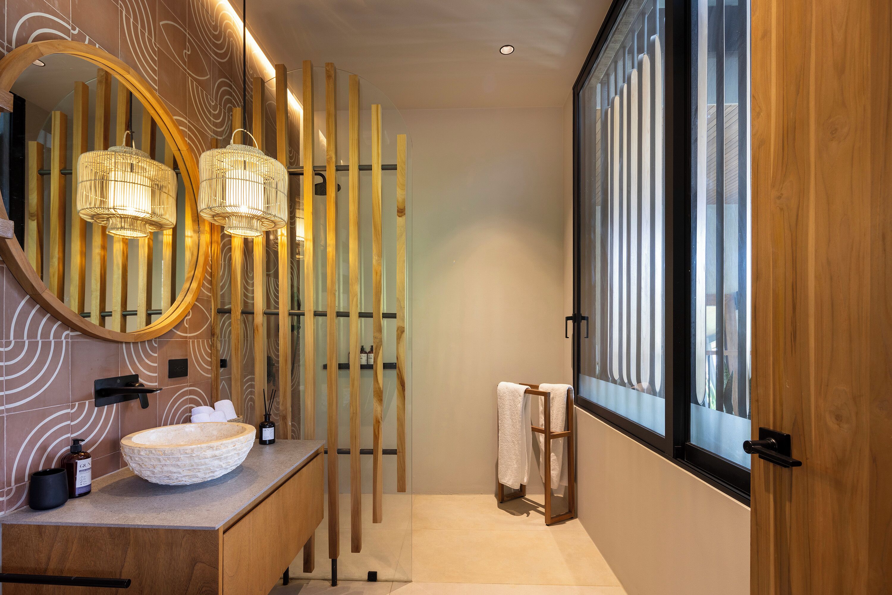 A modern bathroom with a large mirror, wooden panel wall, and a large window.