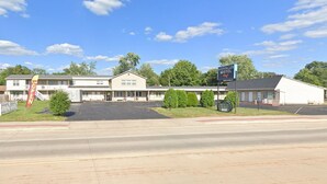 A motel with a signboard, a parking lot, and a road in front. - Prairie Voyager  (Prairie Du Chien)