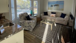 Een moderne woonkamer met een bank, salontafel en een schilderij aan de muur.