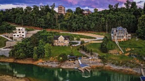 A lakeside property with multiple houses, a dock, and a well-maintained lawn. - Enjoy luxury Sunsets at the Lake! (SEVIERVILLE)