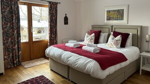 A bedroom with a bed, curtains, a radiator, a painting, and a skylight. - SECLUDED COTTAGE IN THE VERY HEART OF THE HIGHLANDS OF SCOTLAND (Kingussie)