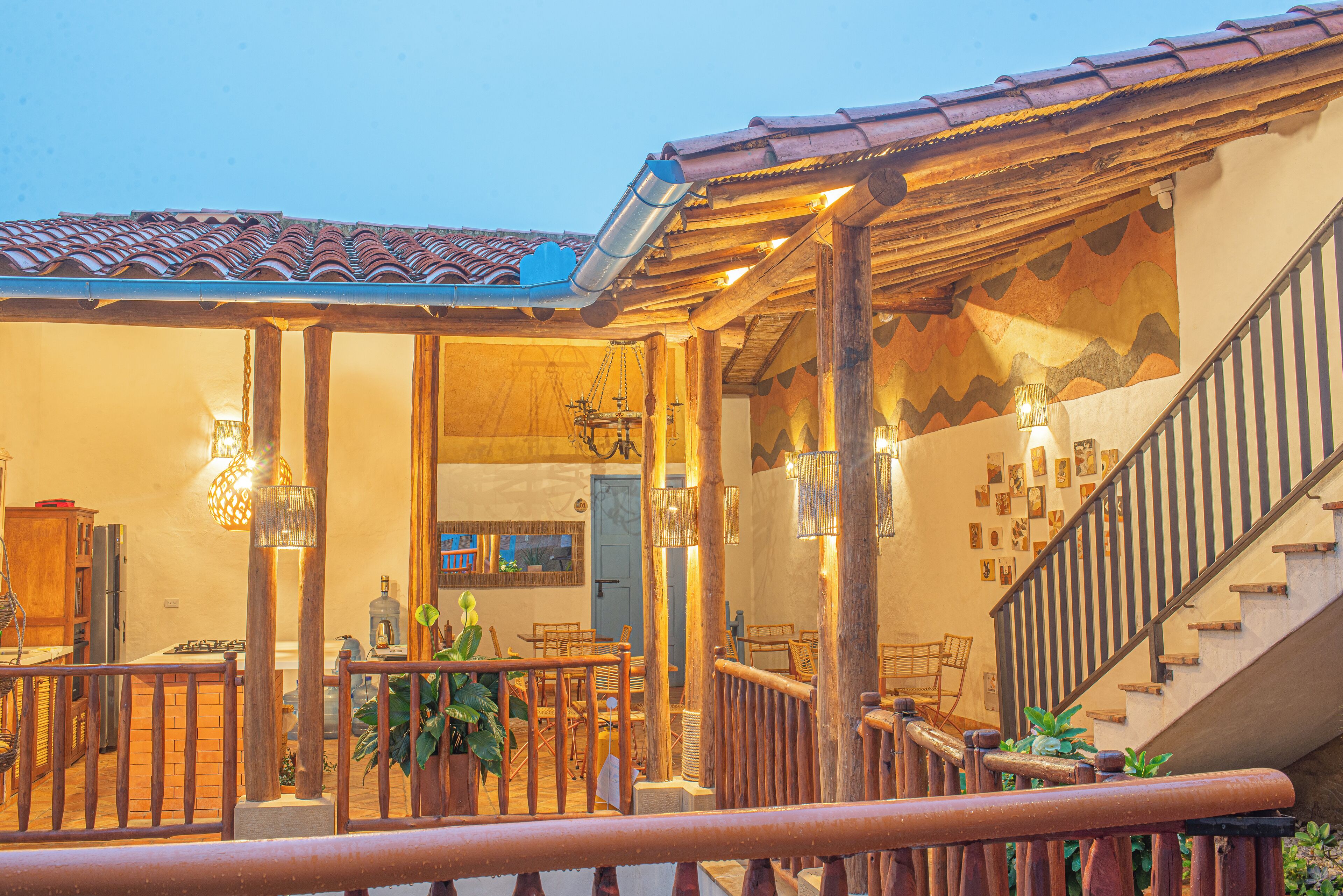 A cozy interior with a wooden staircase, a dining area with chairs and a table, and a kitchen area with a stove and cabinets.