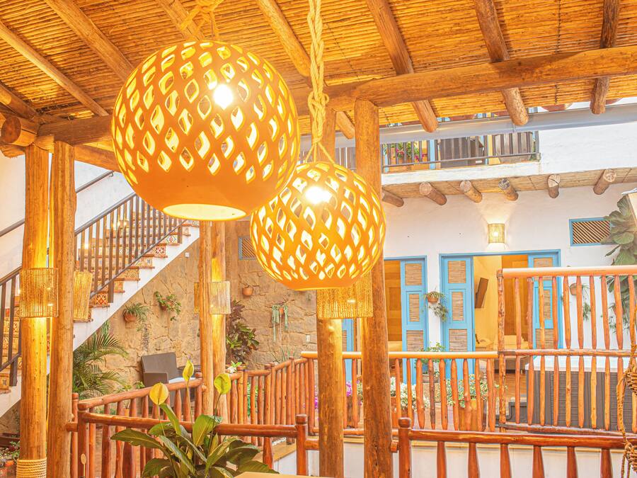 A wooden staircase with a railing, a hanging light fixture, and a balcony with a railing.