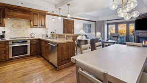 A modern kitchen with wooden cabinets, a central island, and pendant lighting. - The Aspen Mountain Residences 16B - 1 Bedroom Residence (Aspen)