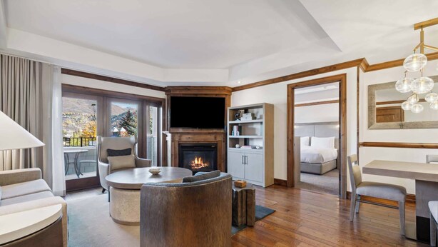 A modern living room with a fireplace, a round coffee table, and a comfortable seating area. - The Aspen Mountain Residences 16B - 1 Bedroom Residence (Aspen)