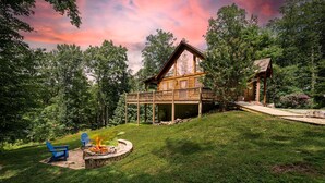 A cabin with a deck, a fire pit, and two Adirondack chairs. - Hot tub, Firepit, Beautiful Mountain Views! (Stanardsville)