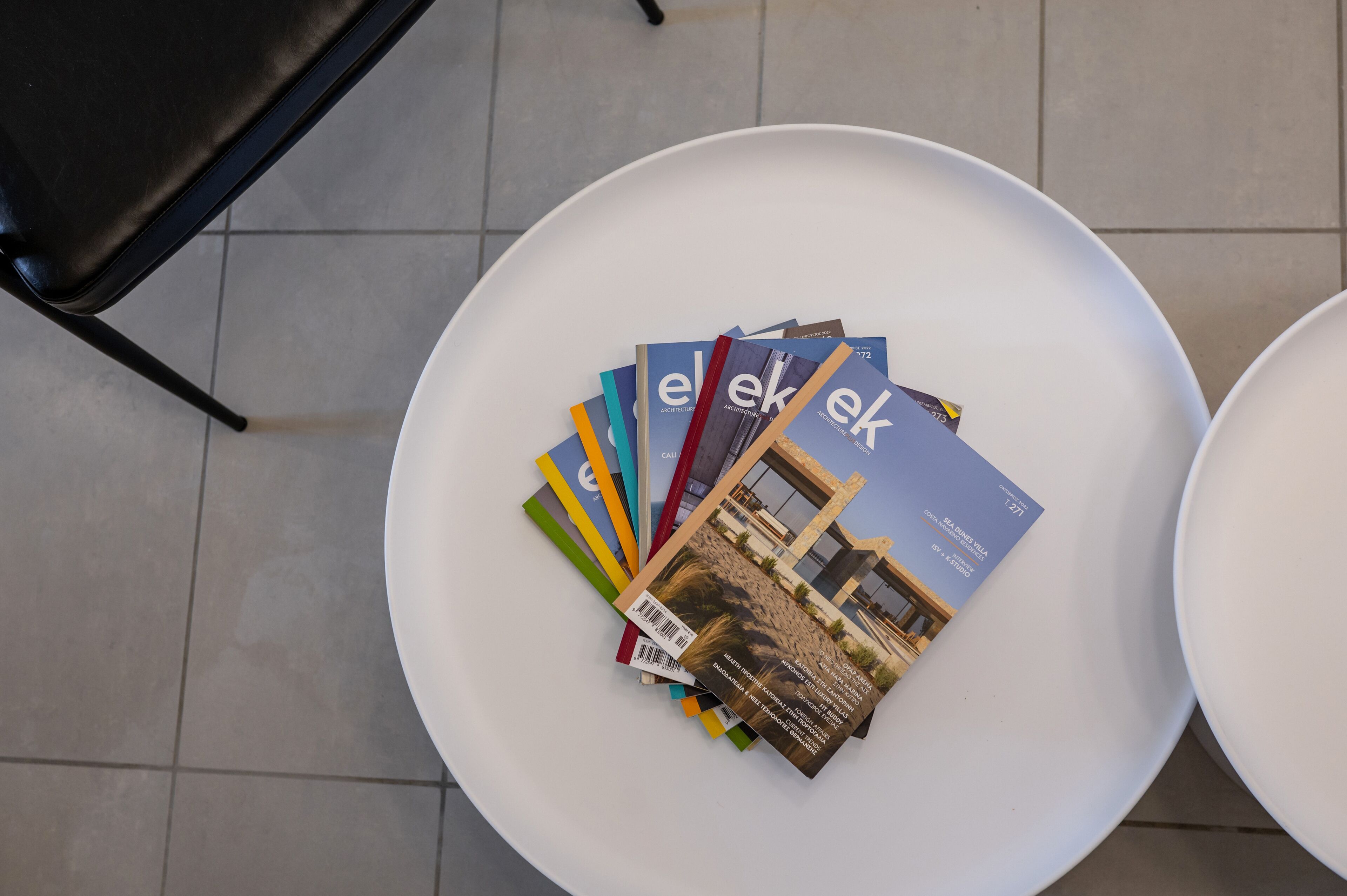 Una mesa blanca con varias revistas encima.