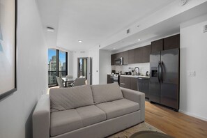 Deluxe-Apartment, Balkon, Stadtblick | Wohnbereich | 50-Zoll-Smart-TV mit Kabelempfang