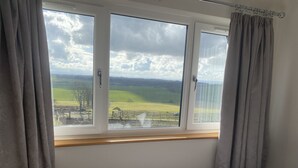 Une pièce dotée d’une grande fenêtre donnant sur un paysage verdoyant.