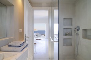 Villa | Badkamer | Een aparte badkuip en douche, een diep bad, een haardroger, handdoeken