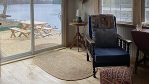 Una baita accogliente con una grande finestra vista lago, arredamento in legno e interni rustici.