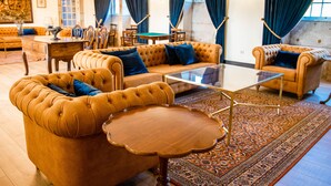 A spacious living room with a large sofa, a coffee table, and a patterned rug. - Quinta do Convento Val Pereiras (Ponte de Lima)