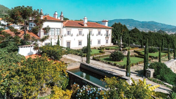 A large white building with a red-tiled roof, surrounded by lush greenery and a well-maintained garden. - Quinta do Convento Val Pereiras (Ponte de Lima)