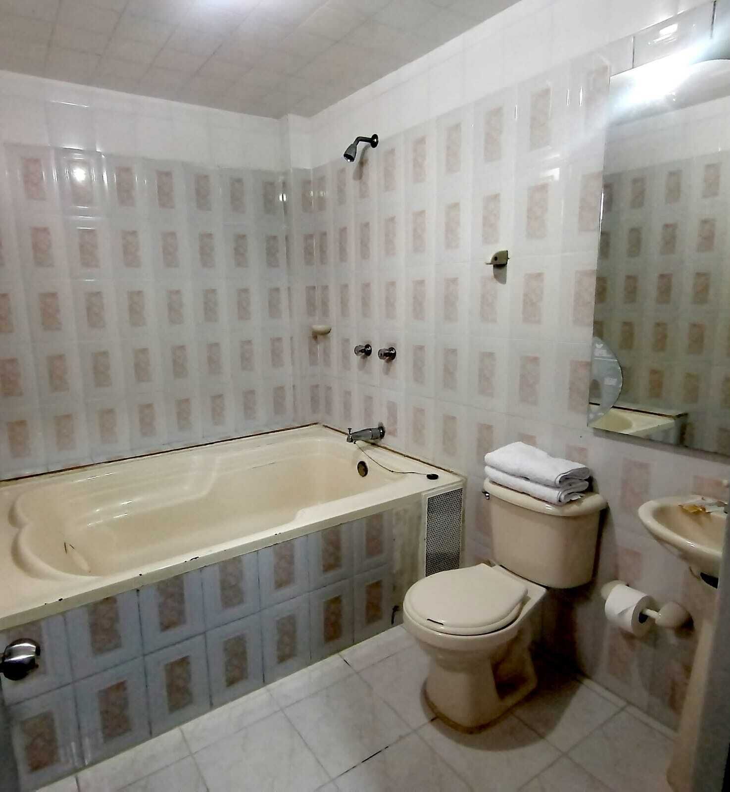 A bathroom with a bathtub, toilet, and sink.