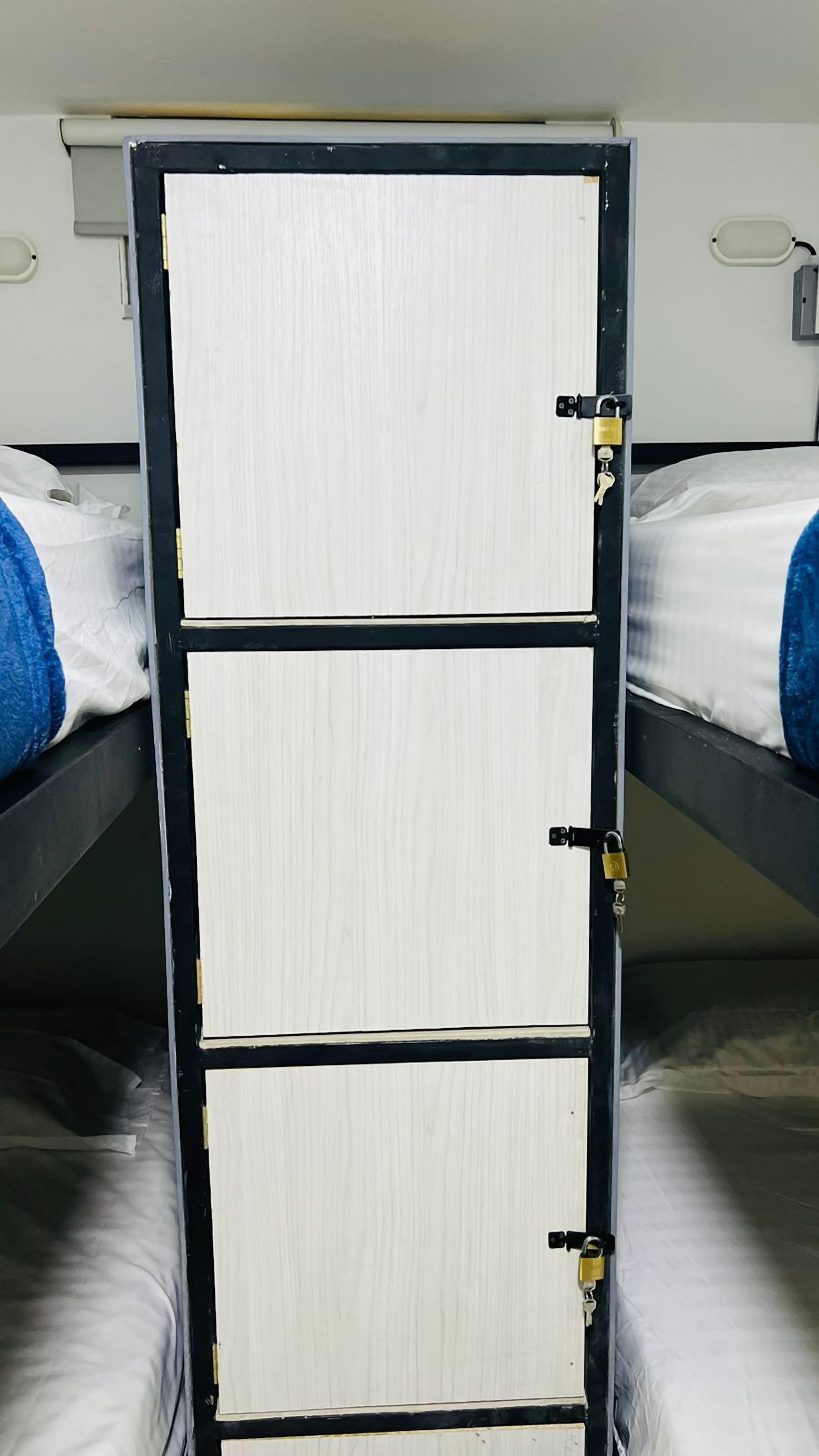 A bunk bed with a metal frame and white panels, featuring a lock and keys on the side.