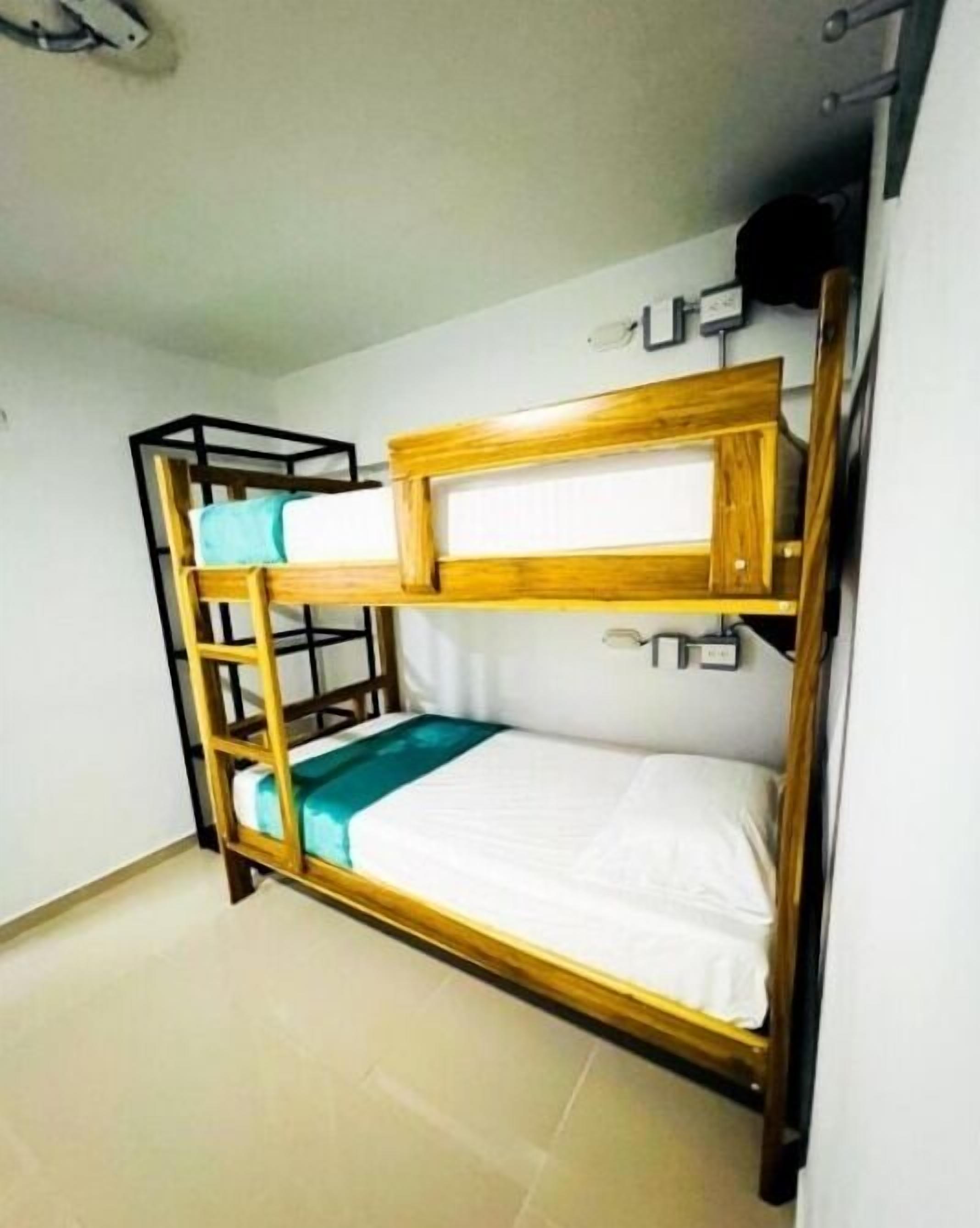 A bunk bed with a wooden frame and a single mattress.