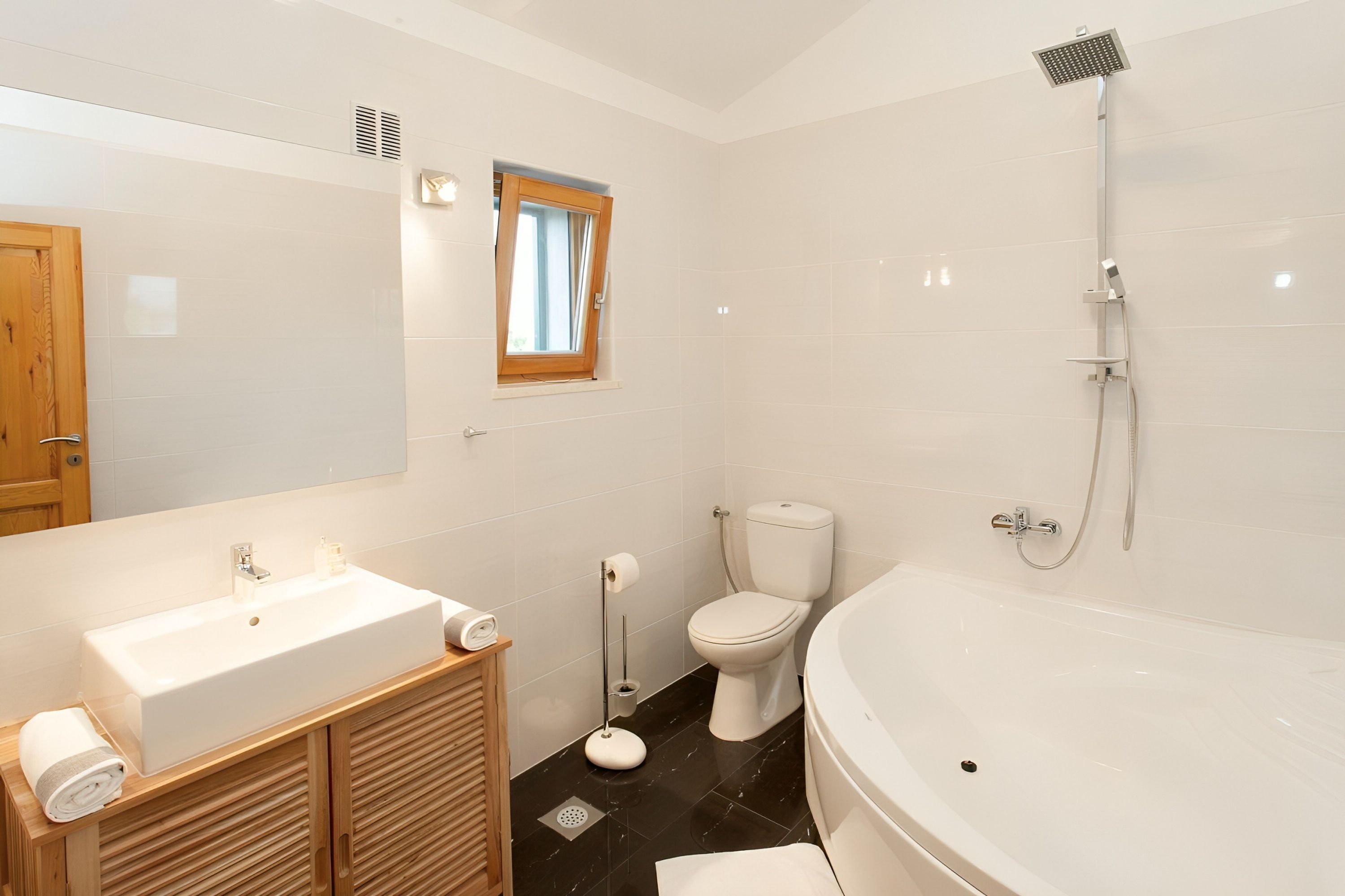 A modern bathroom with a large sink, toilet, and bathtub.