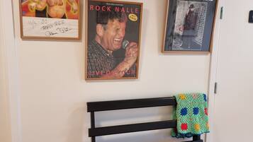 A room with a black bench, a white door, and four framed posters on the wall.