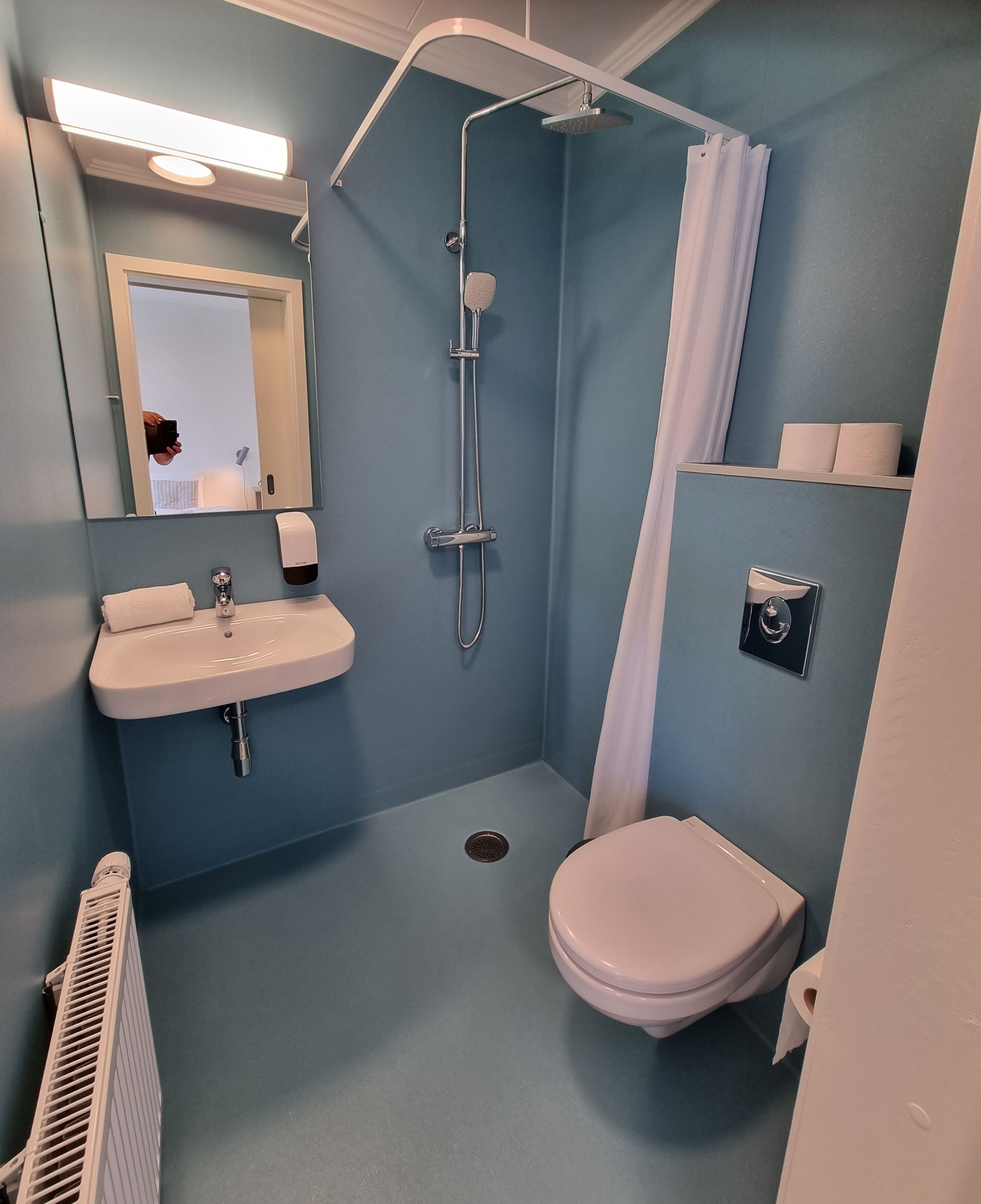 Ein kleines Badezimmer mit Waschbecken, Toilette und Dusche.