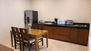 A compact kitchen with a dining table, chairs, a refrigerator, a microwave, a stove, and a coffee maker. - Apartment Palma Comfort in Downtow, Pool (Mérida)