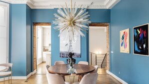 A dining area with a round table, six chairs, and a decorative light fixture. - NEW! Brush Park Brilliance! Walk->Stadiums DT Luxe 3BR (Detroit)