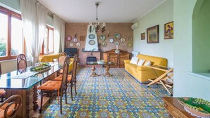 A dining area with a glass table, orange chairs, and a patterned floor. - Villa Mimma (Sant'Agnello)