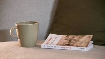 A book titled "Montal Thomas" and a mug on a textured surface.