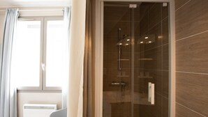 A modern bathroom with a glass-enclosed shower, a white radiator, and a window with curtains. - Le Jostel 5 _ Chemin de la petite Rive (Genay)