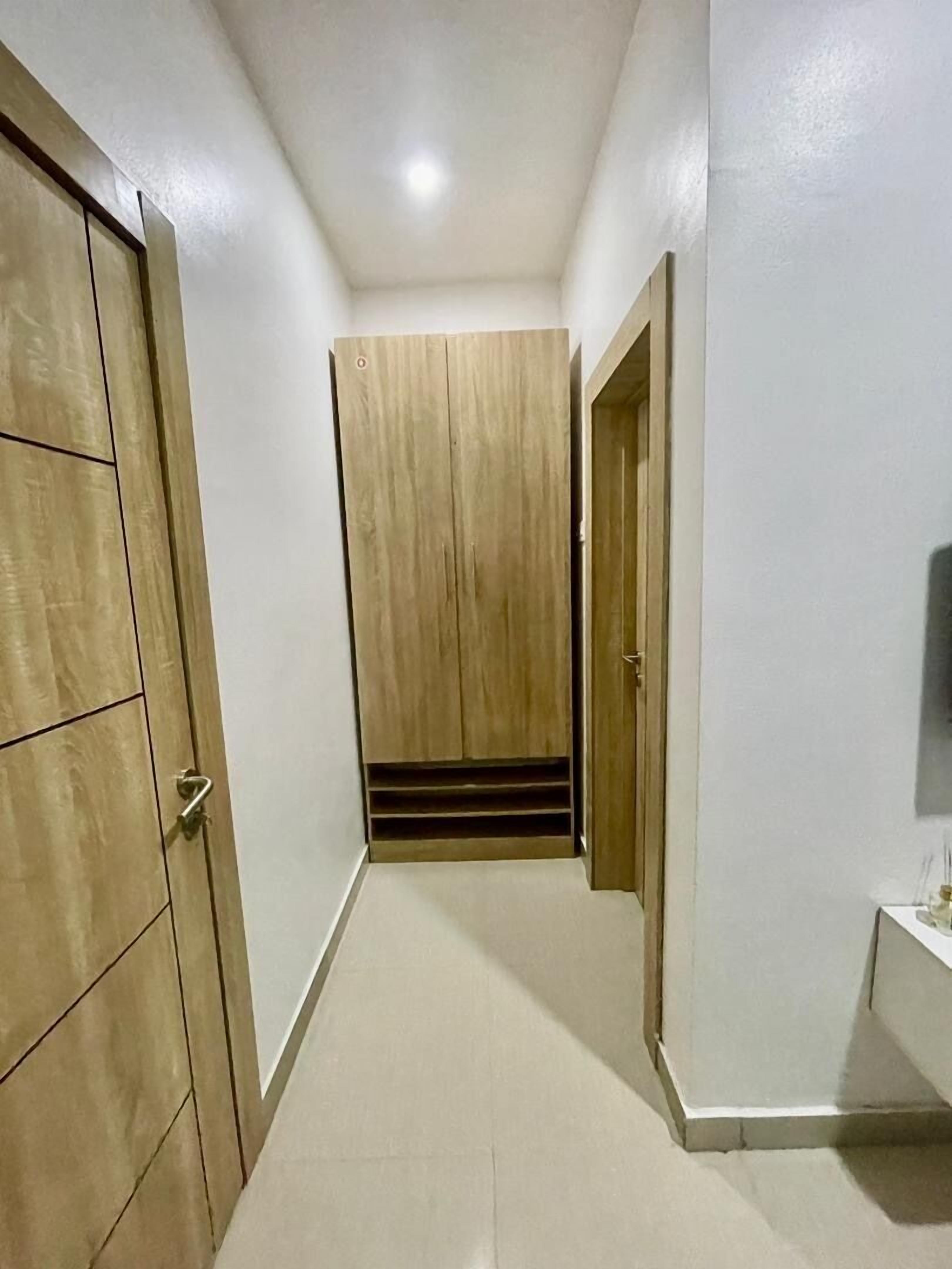 A hallway with wooden doors and a built-in wardrobe.