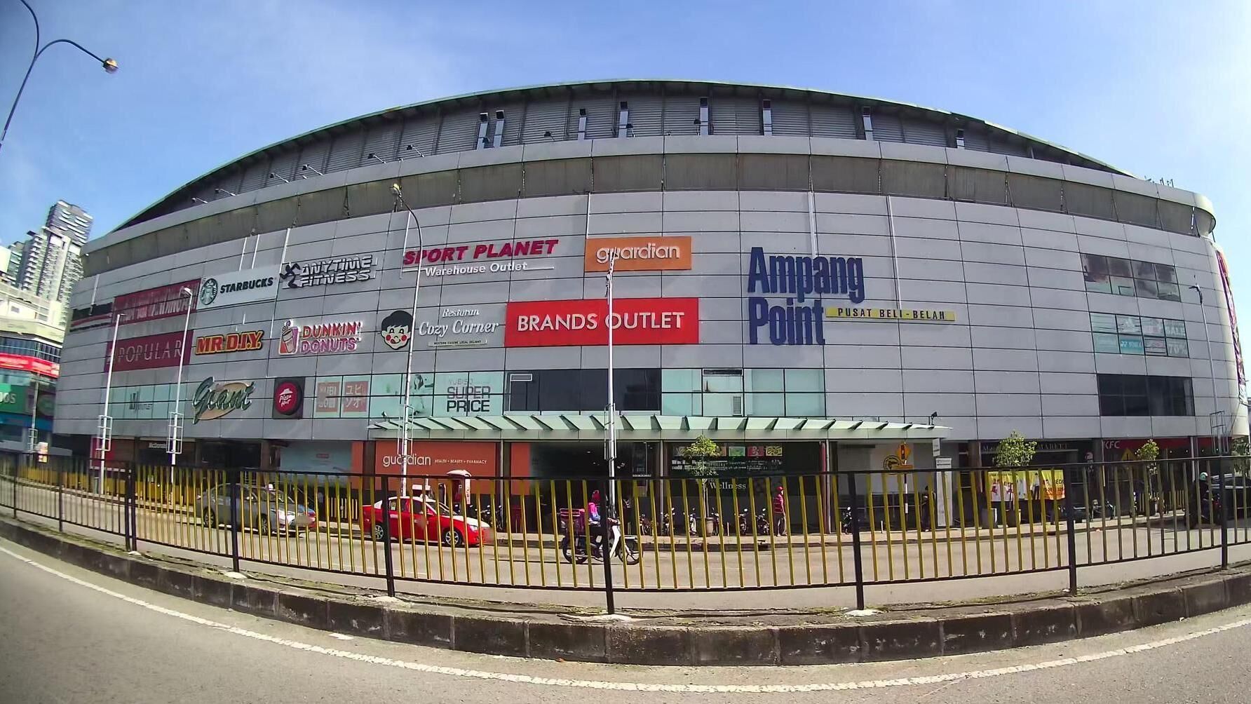 A large commercial building with multiple storefronts including Starbucks, Dunkin' Donuts, and AMPANG Point.