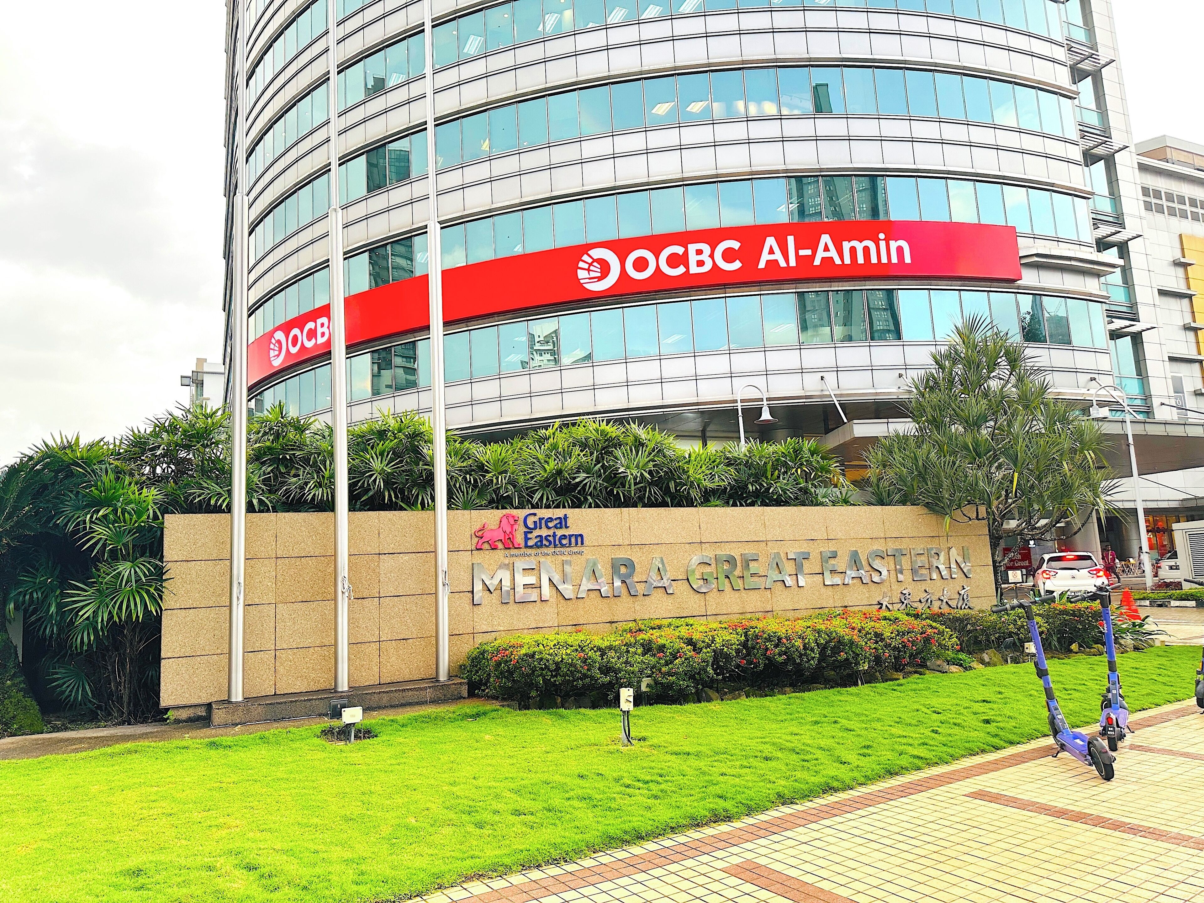 Ein modernes Gebäude mit einem Schild für OCBC Al-Amin und Great Eastern Menara.