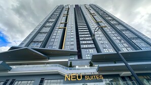 A high-rise building with multiple balconies and a sign for "NEU SUITES". - Neu Suites By Serenity Vacation Homes (Kuala Lumpur)