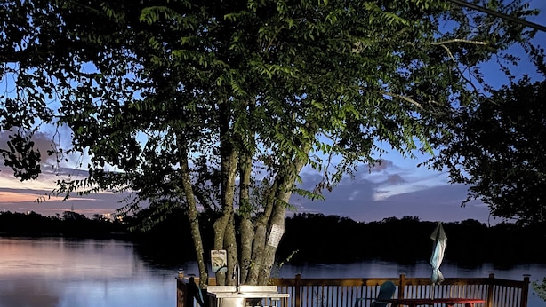 En terrass vid sjön med ett picknickbord och ett litet utomhushandfat.