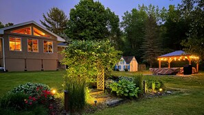 Ein gepflegter Garten mit verschiedenen Pflanzen und einer Pergola.