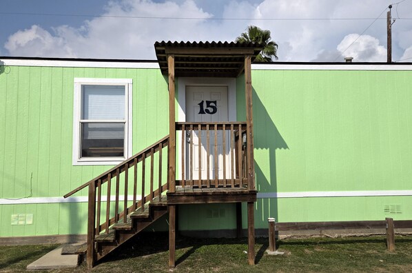 Un bâtiment écologique avec un escalier en bois menant à une porte portant le numéro 15.